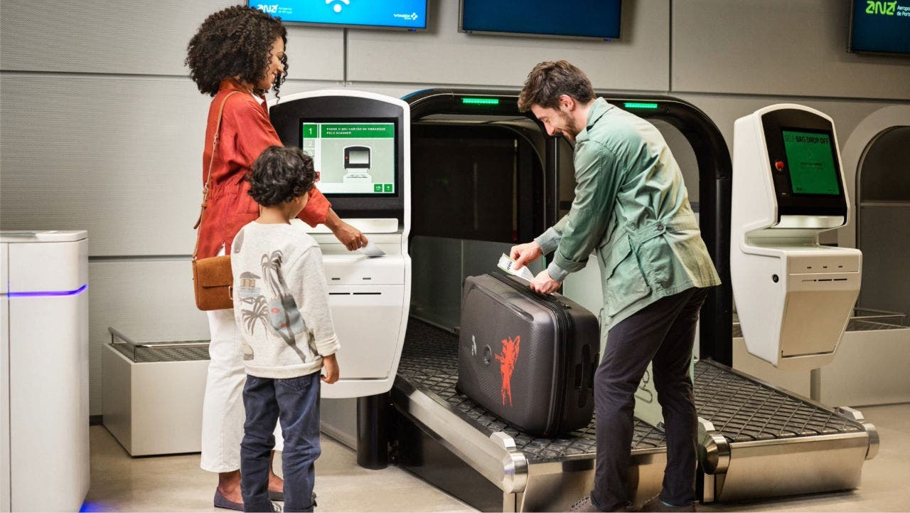 Une famille à l’aéroport utilise une borne en libre-service pour l’enregistrement des bagages, tandis qu’un homme place une valise sur un tapis roulant automatique. Une famille à l’aéroport utilise une borne en libre-service pour l’enregistrement des bagages, tandis qu’un homme place une valise sur un tapis roulant automatique.